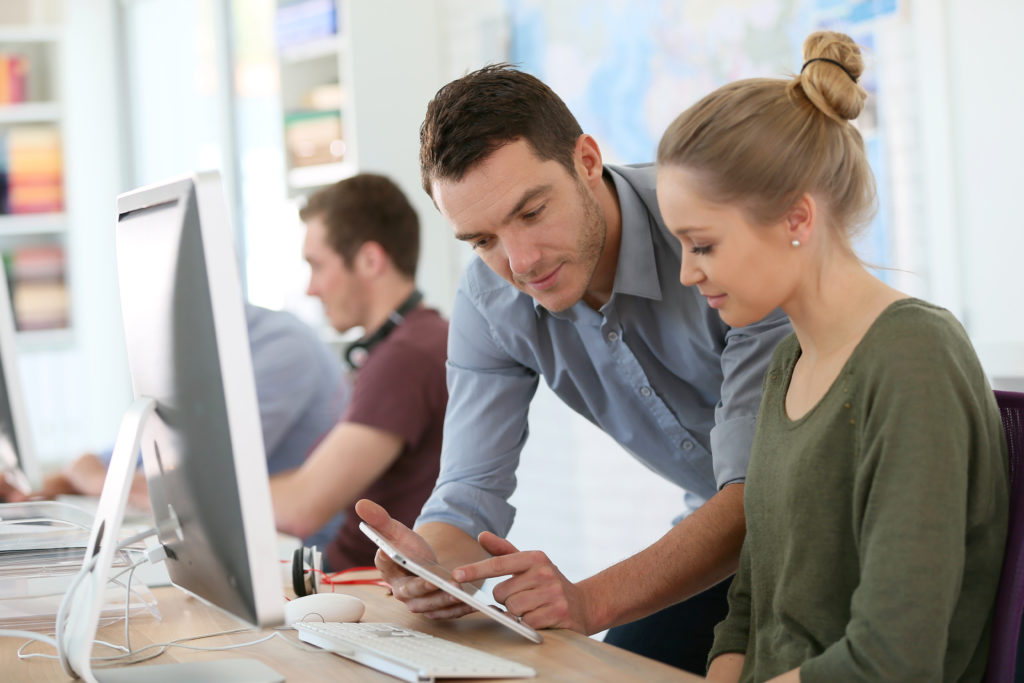 Student girl with trainer working on computer and tablet